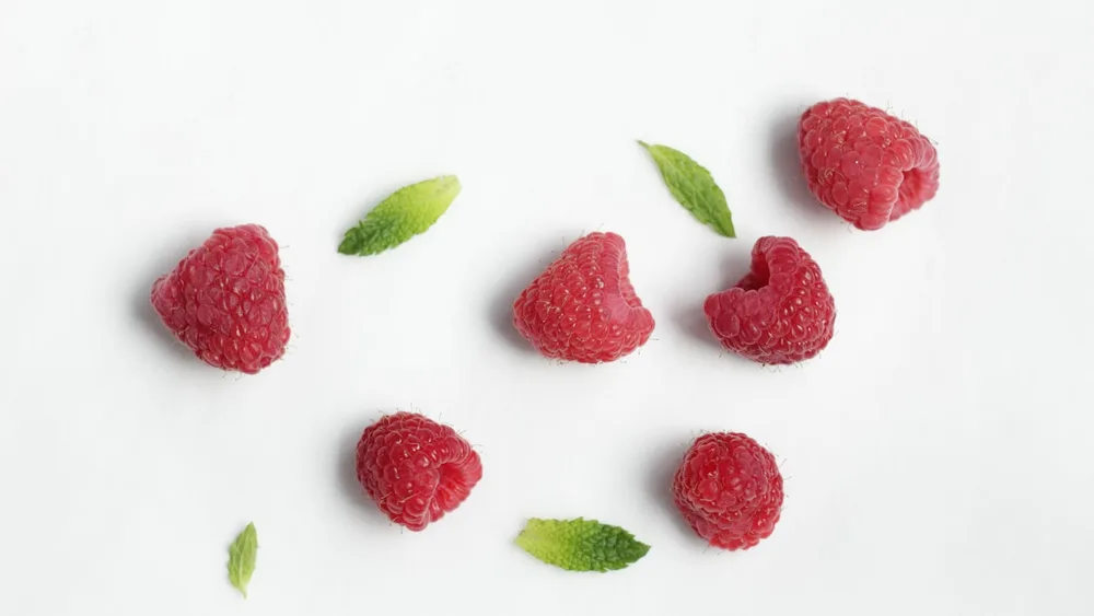 Fresh raspberries with scattered mint leaves - nutrition talks and presentations for Cape Town schools and businesses